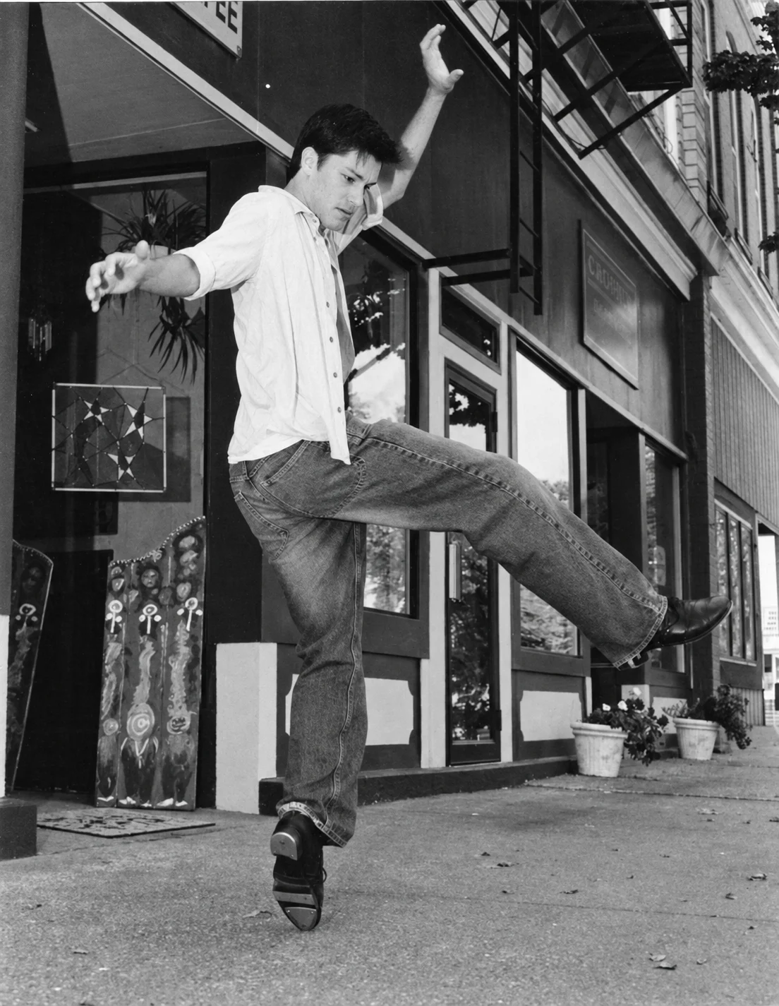 Zach Villa balancing on the toe of his tap shoe, one leg extended